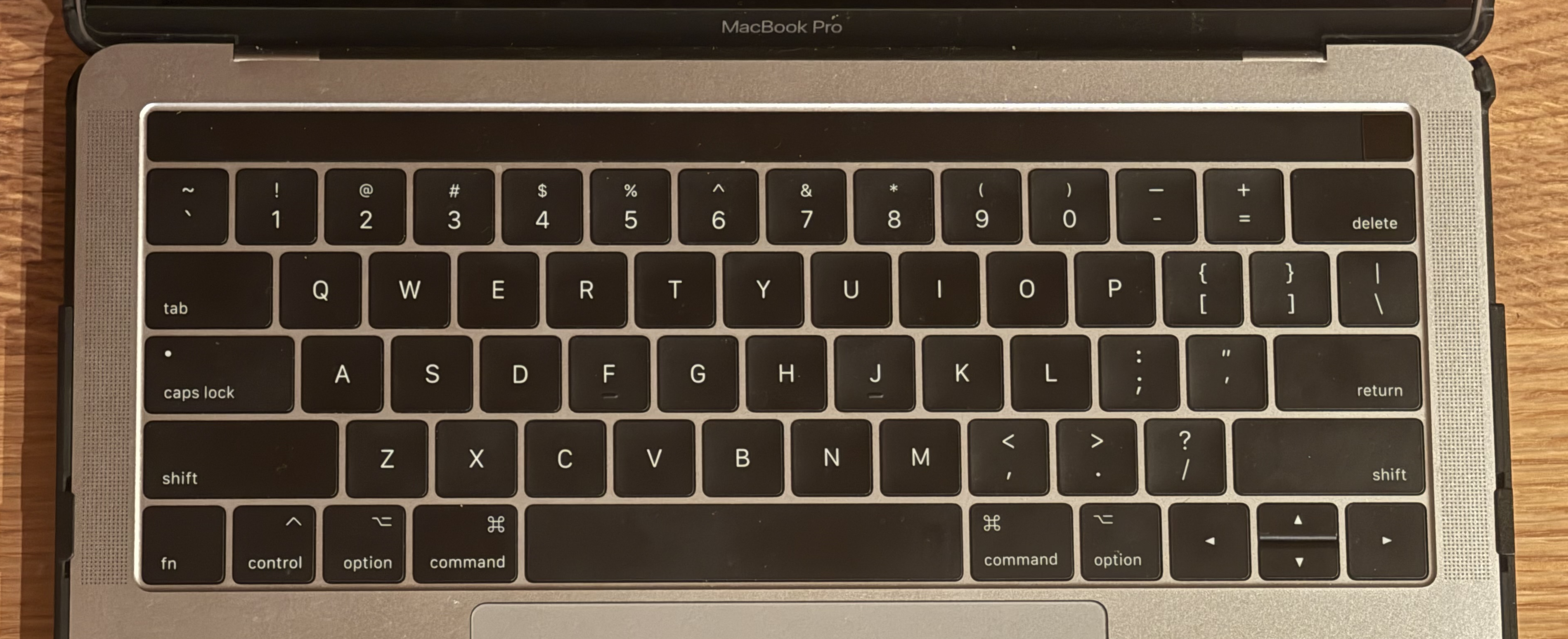 Photo of 13" 2016 Macbook Pro with Touch Bar keyboard. Alt says "Option" and has the Alt symbol on it, Command Key says "command" and has the command symbol on it, Enter key says "return"